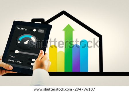 Man using tablet pc against energy efficient house graphic against a white background