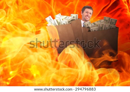 Businessman carrying bag of dollars against fire