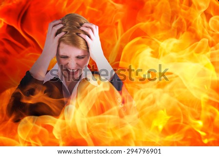 Stressed businesswoman with hands on her head against fire