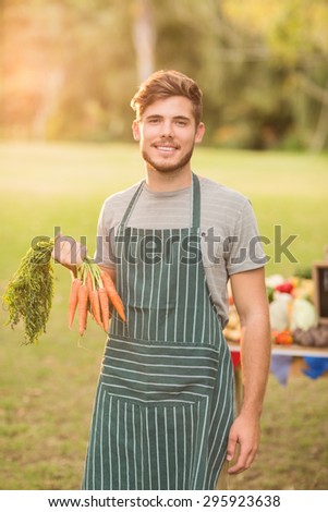 Handsome farmer smiling at camera on a sunny day