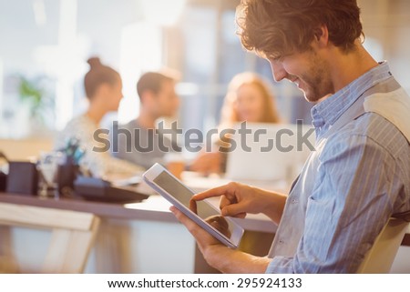 Smiling young man using digital tablet in the office