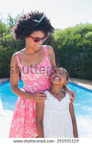 Happy mother and daughter smiling at each other in the garden at home