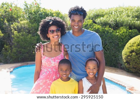Happy family smiling at camera in the garden at home