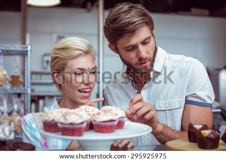 Cute couple on a date choosing cakes at the bakery