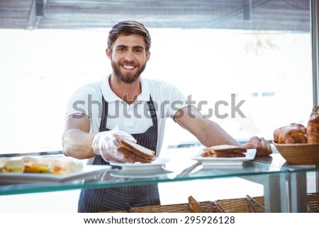 Happy server showing sandwich at camera