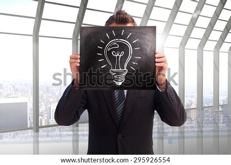 Businessman showing board against room with large window looking on city