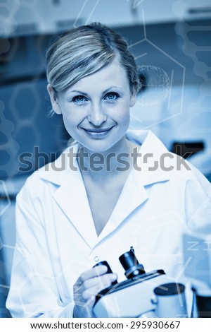 Science graphic against smiling female scientist using a microscope