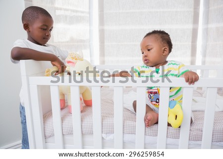 Babyboy playing with his brother in his bed at home in bedroom