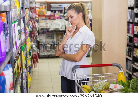 Woman buy products with her trolley at supermarket