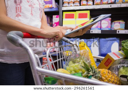 pretty woman using a tablet in a supermarket