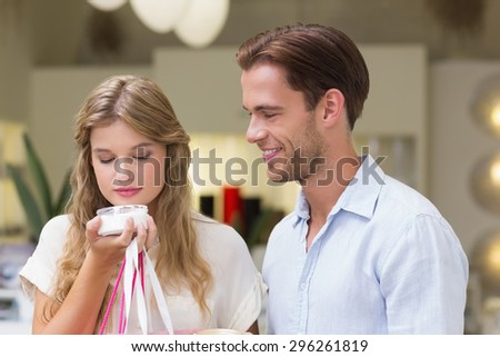 A couple testing a sample of beauty products in the mall