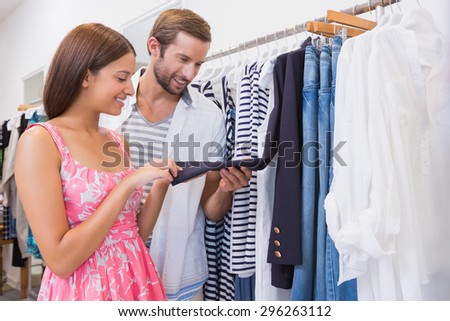Smiling couple looking at clothes at a boutique