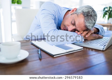 Businessman sleeping on laptop computer in office