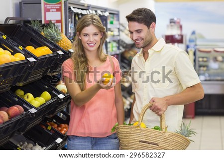 Portrait of smiling bright couple buying food products at supermarket
