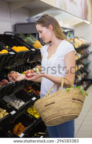 Smiling pretty blonde woman buying products at supermarket