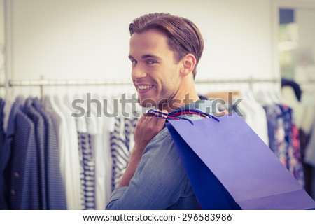 Portrait of a smiling man with shopping bags at the clothing store