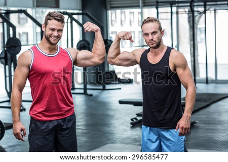 Portrait of two muscular men flexing biceps