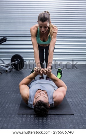 Muscular couple doing core exercises at the crossfit gym