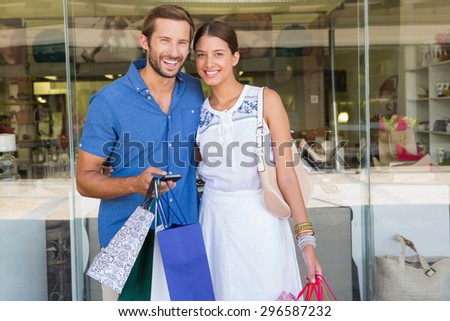 Young happy couple looking at camera after shopping
