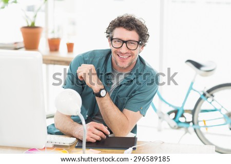 Cheerful graphic designer using a graphics tablet in a modern office