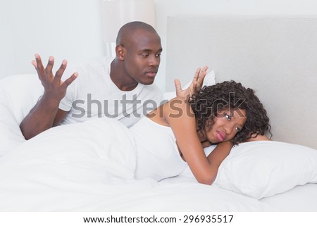Dispute between a couple in bed together at home in bedroom