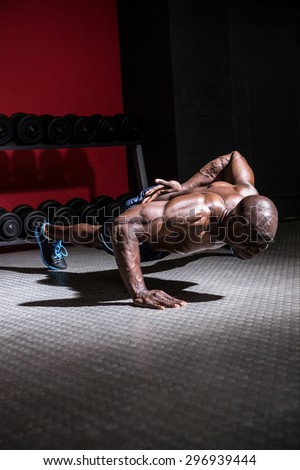 Young Bodybuilder doing One-armed push ups in front of the camera