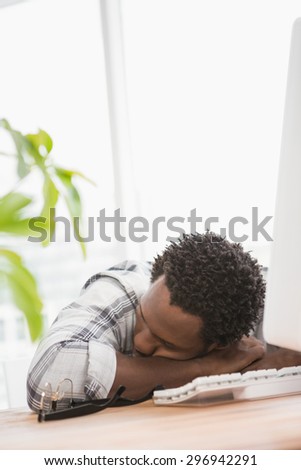 Tired casual businessman sleeping on desk in the office