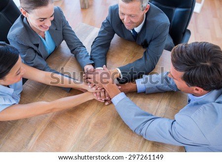 Business people joining hands in a circle in the office