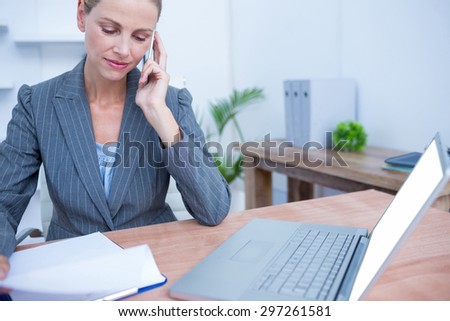 Pretty blonde businesswoman phoning