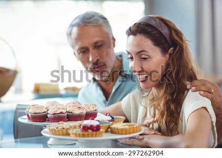 Cute couple looking at pastries in the bakery store