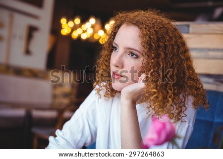 Young woman lost in her thoughts at the cafe