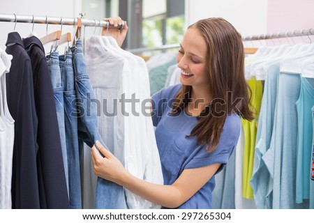 Enthusiastic pretty brunette browsing in the clothes rack