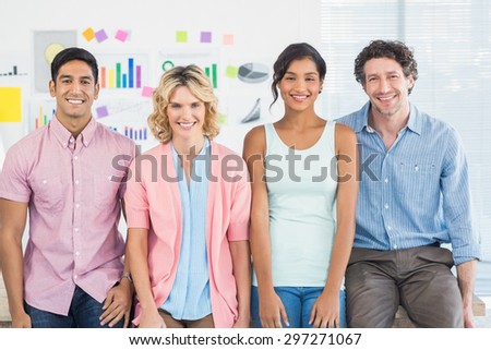Smiling colleagues standing and posing in a line in the office