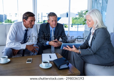 Business people looking at tablet computer in office