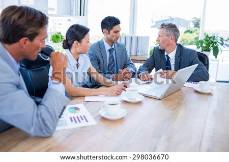 Business people speaking together during meeting in office