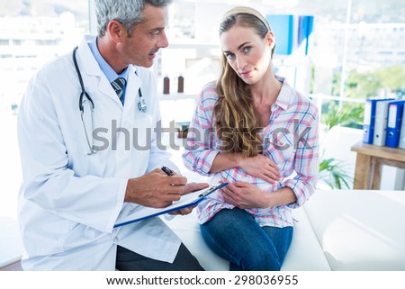 Sitting pregnant woman talking to her doctor in a room