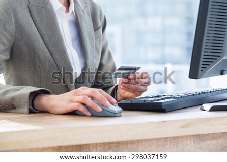 Businessman pay with her credit card on internet at the office