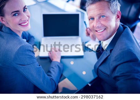 Happy business people looking at camera in office