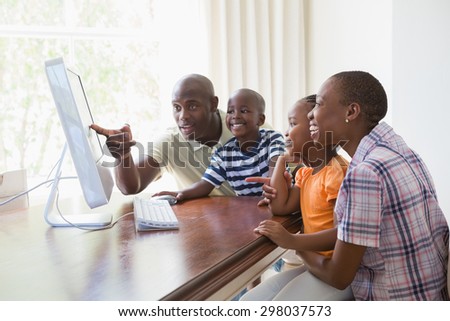 Happy smiling family using computer at home