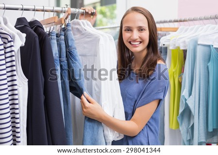 Portrait of a pretty brunette browsing in the clothes rack