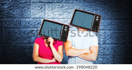 Young couple with bags over heads against dark grey room