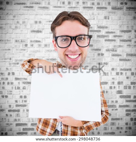 Geeky businessman showing card against grey brick wall