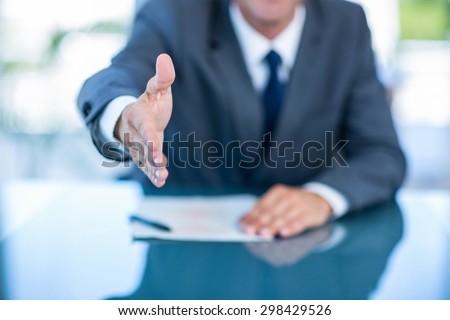 Businessman ready to shake hand in office