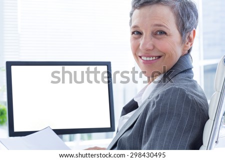 Portrait of smiling businesswoman using computer at the office