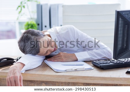 Tired businessman sleeping at her desk on the office