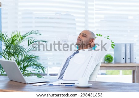 Relaxed businessman lying down in swivel chair at office