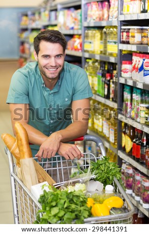 Portrait of smiling man buy product with his trolley at supermarket