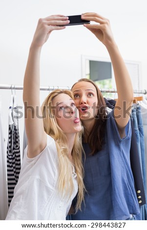 Happy friends taking a selfie while doing funny faces