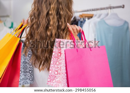 Back view of woman holding shopping bags at a boutique