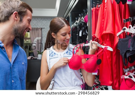 Young happy smiling couple looking at clothes in the clothes store